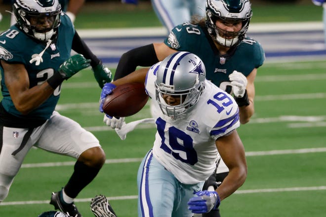 Dallas Cowboys wide receiver Amari Cooper (19) gains long yardage after a catch as Philadelphia Eagles cornerback Michael Jacquet (38) and Alex Singleton (49) gives pursuit in the second half of an NFL football game in Arlington, Texas, Sunday, Dec. 27. 2020. (AP Photo/Ron Jenkins)