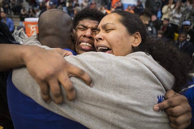 A.I. Dupont's Azeem Bell, center, is overcome with emotion with his father and coach Ian Bell, left, and mother Heather Bell after winning the 195 pound class in the DIAA Individual Wrestling Tournament at Cape Henlopen High School in February.
